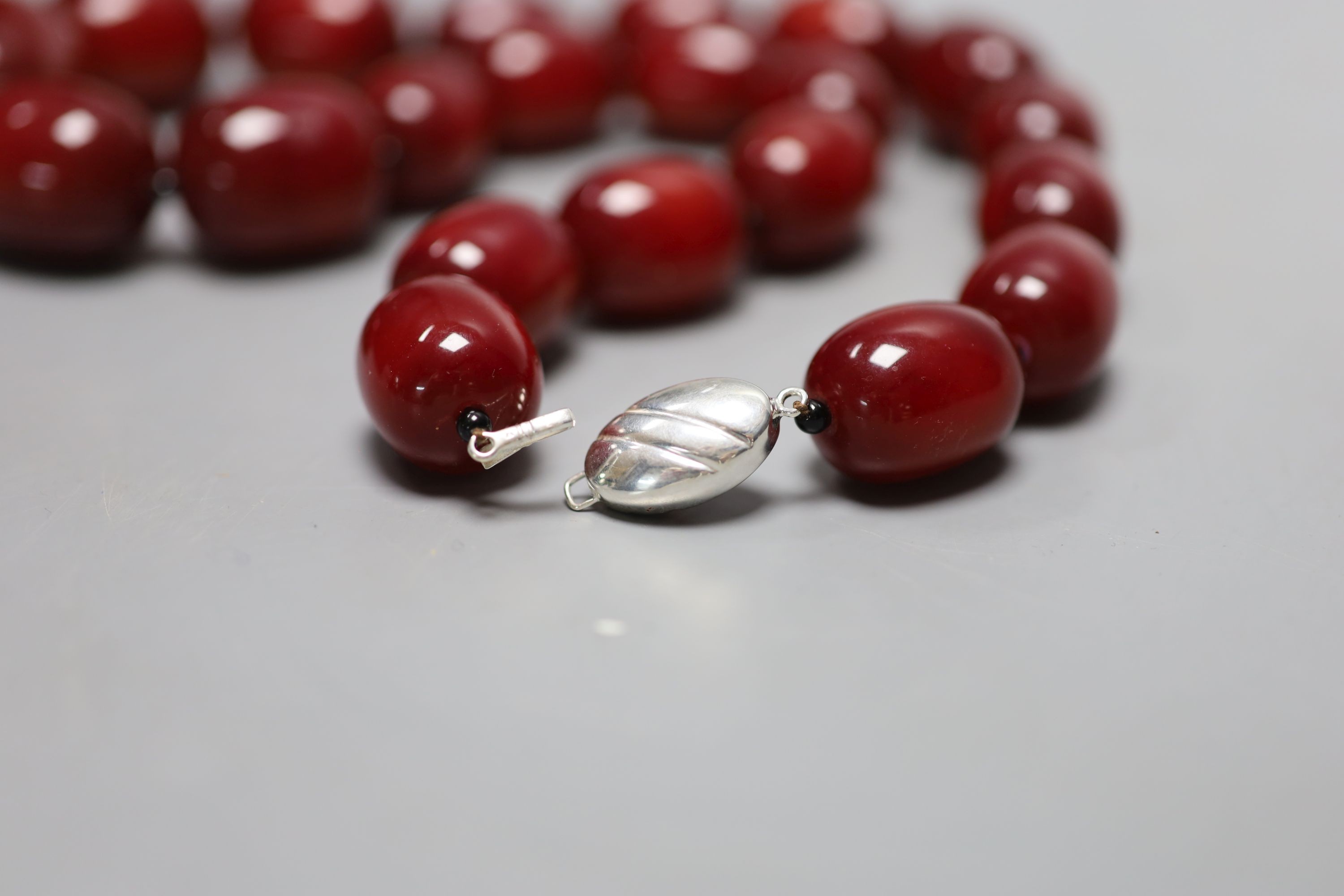 A single strand graduated simulated cherry amber bead necklace, 66cm, gross weight 216 grams.